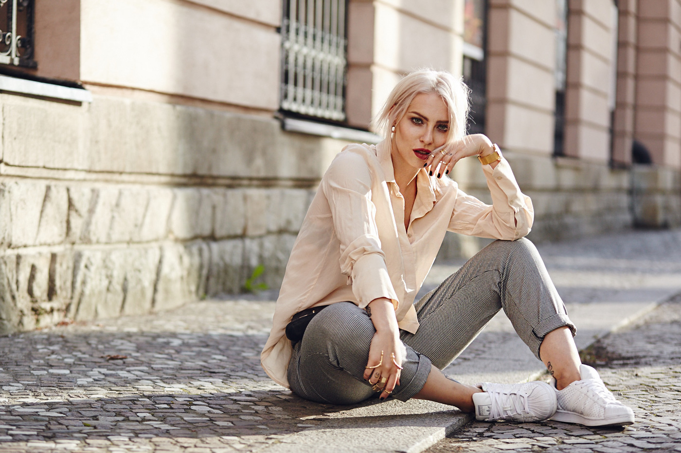 street style from Berlin via Masha Sedgwick | casual office fashion outfit | Masha is wearing Adidas Superstar sneaker, a black Elizabeth & James belt bag, a golden hand cuff, a nude silk shirt, a hound's-tooth checked pants