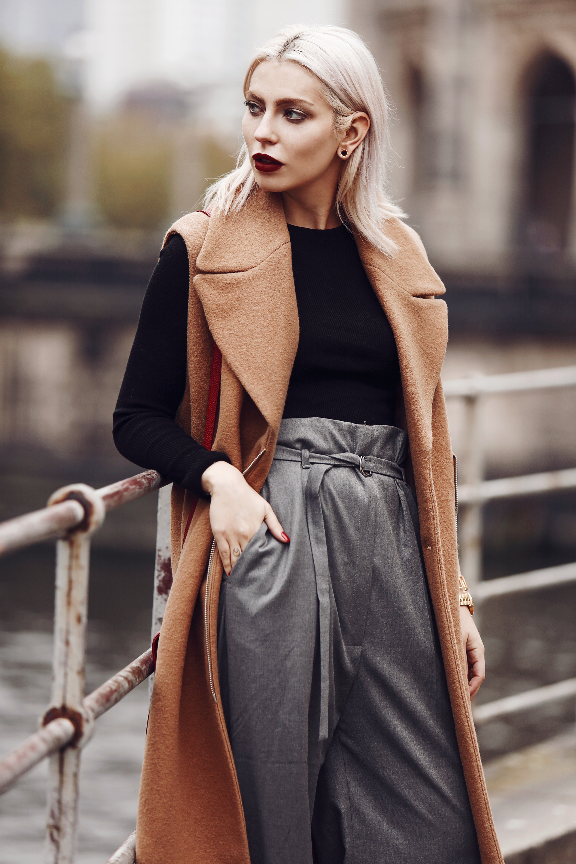 Outfit: Casual Business via Masha Sedgwick | wearing a classy red bag from Aigner, wide grey marlene trousers from Carin Wester, black crop top, a brown wool vest | street style from Berlin | effortless chic