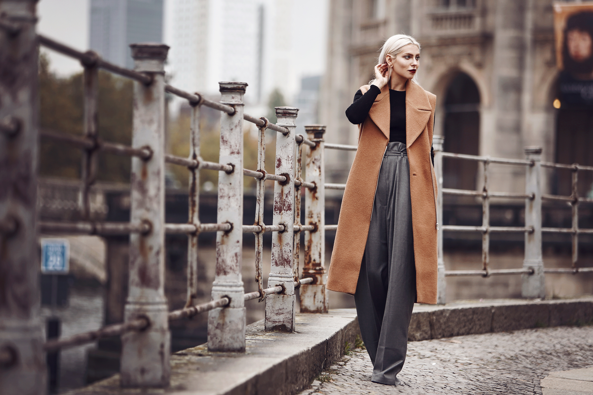 Outfit: Casual Business via Masha Sedgwick | wearing a classy red bag from Aigner, wide grey marlene trousers from Carin Wester, black crop top, a brown wool vest | street style from Berlin | effortless chic