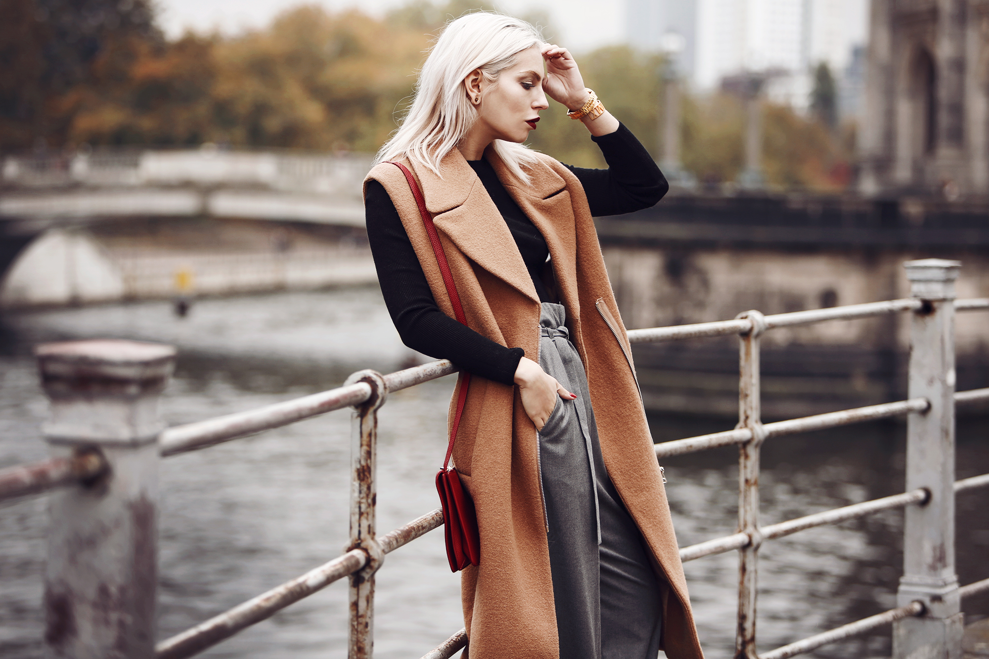 Outfit: Casual Business via Masha Sedgwick | wearing a classy red bag from Aigner, wide grey marlene trousers from Carin Wester, black crop top, a brown wool vest | street style from Berlin | effortless chic