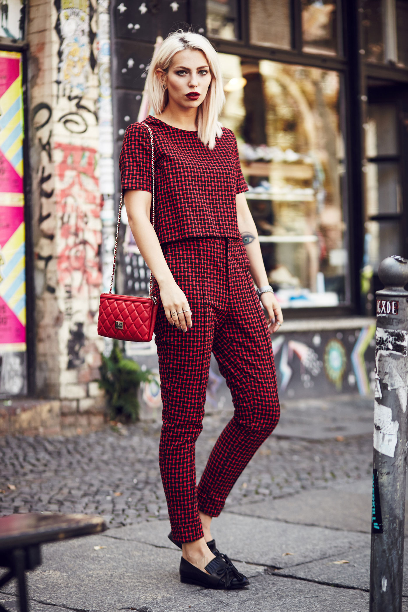 Masha Sedgwick, fashion blogger from Berlin is wearing a red two piece combined with a red Moschino bag and black loafers | Outfit
