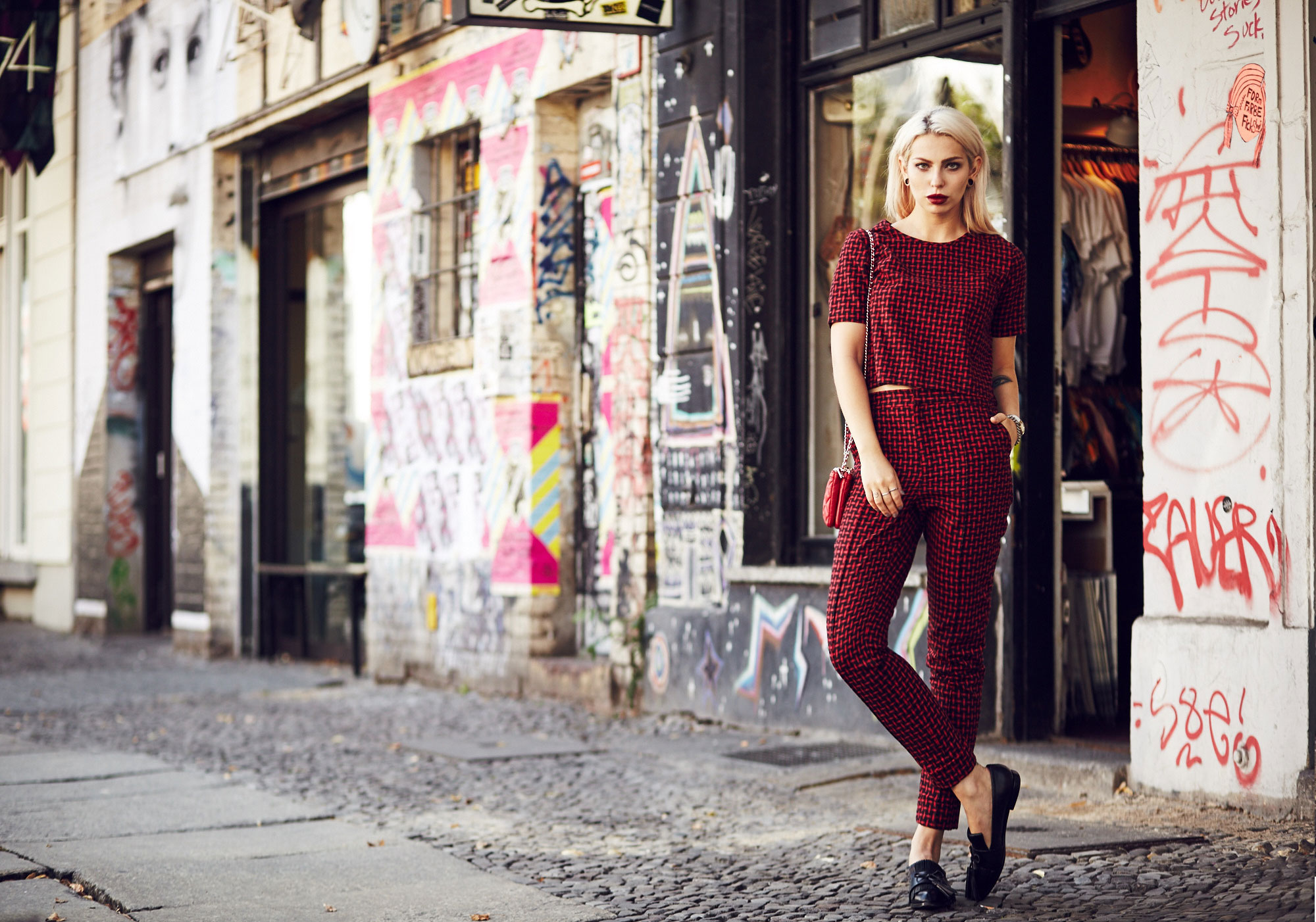 Masha Sedgwick, fashion blogger from Berlin is wearing a red two piece combined with a red Moschino bag and black loafers | Outfit