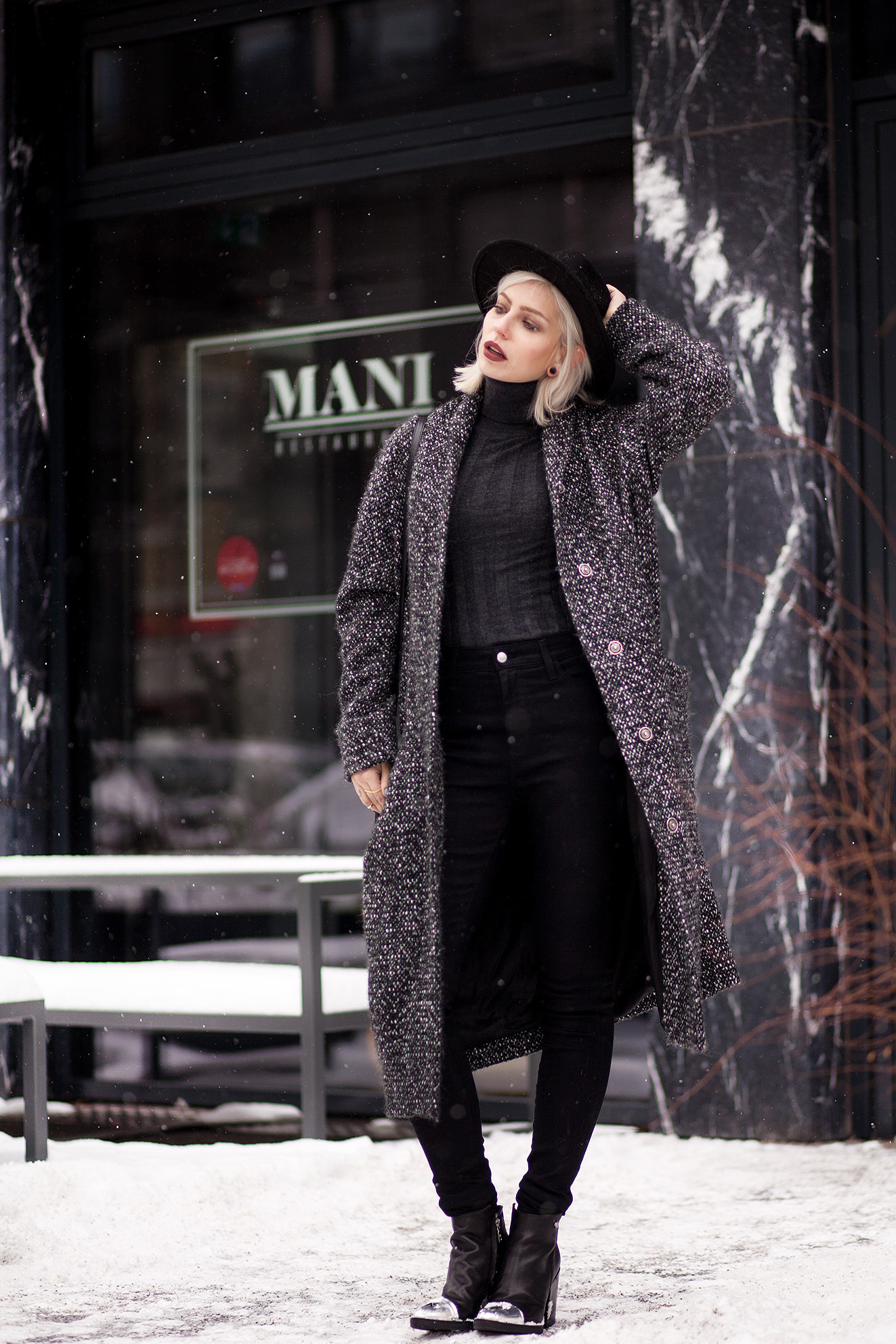 view more details on my blog | wearing black boots with a star from Love Moschino, an oversized wool coat from Marimekko, a black bag from Saint Laurent and a black jeans from AG | black, edgy, winter fashion | street style taken in Berlin | snow