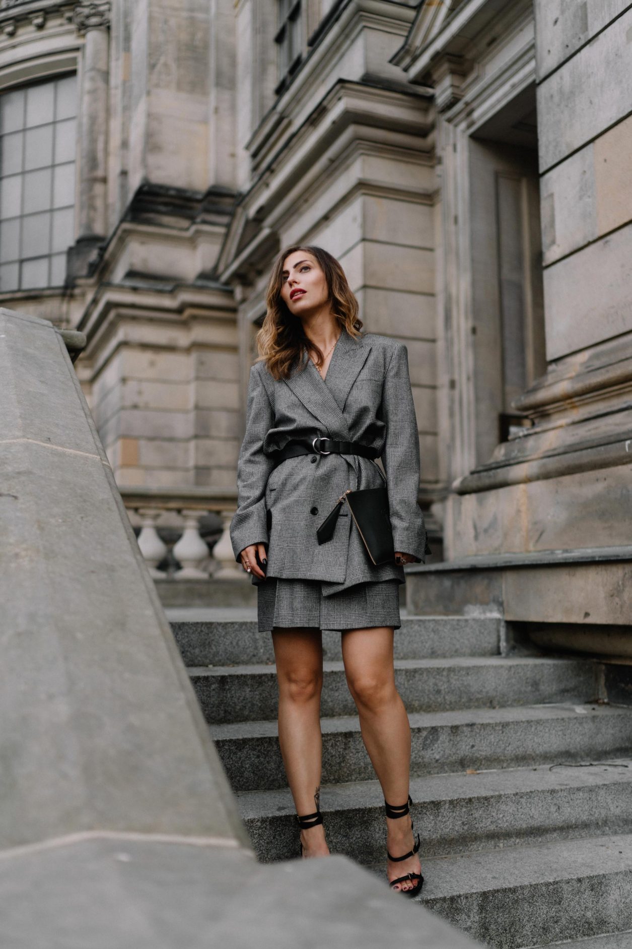 Business look by Max Mara: wearing grey checked crepe suit and mini skirt by Max Mara SS20, black leather envelope clutch by Max Mara, Nappa leather sandals Sylvia by Max Mara new collection, fine jewelry by Thomas Sabo, Georg Jensen, Close, Louis Vuitton; location: Berlin Museum Island, Berliner Dom, Berlin Fashion Blogger