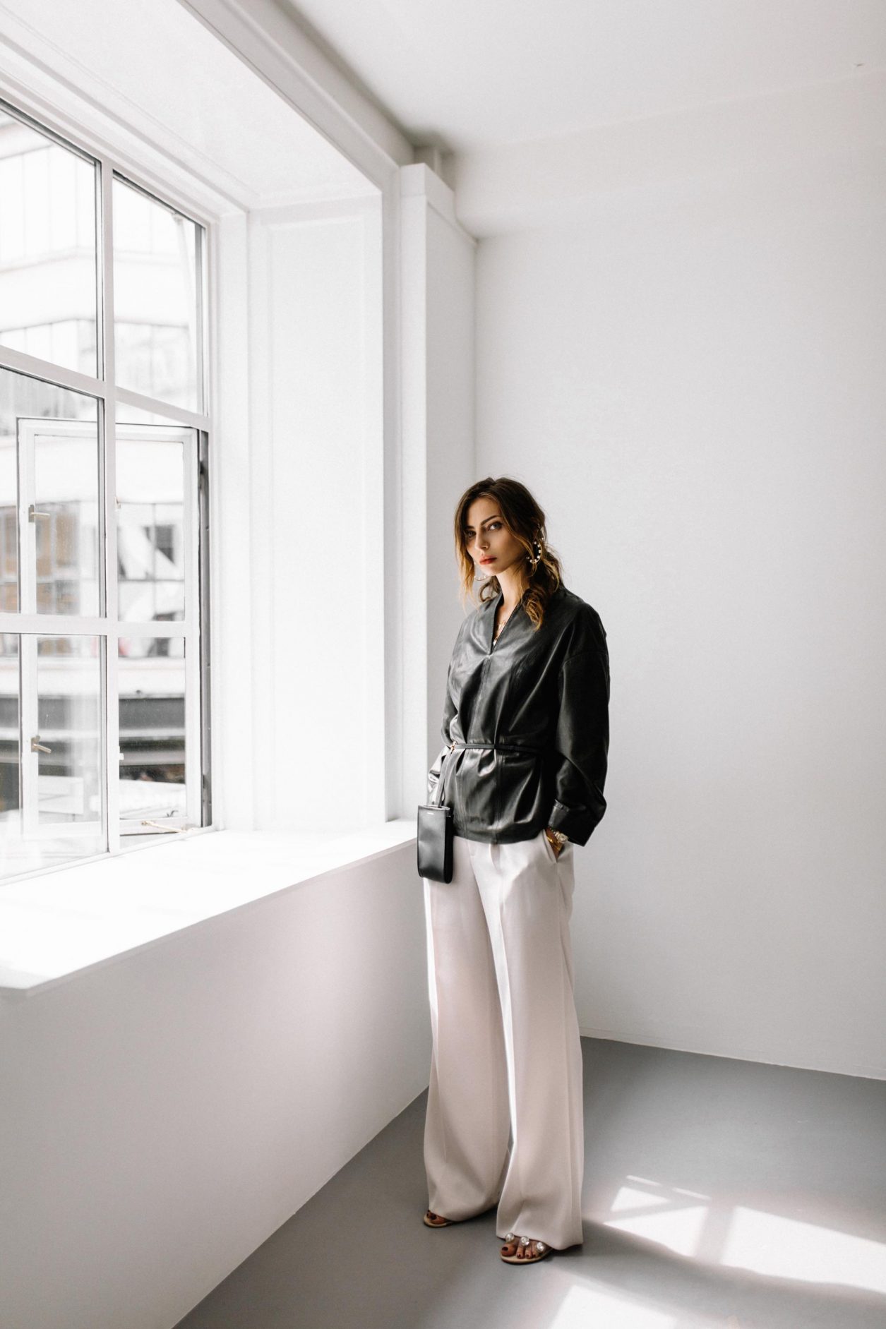 Masha Sedgwick at the CPHFW SS20 wearing black leather shirt by Gestuz, Maria Black jewelry (pearl earring and rings), Thomas Sabo necklace, Rolex watch, belt bag by Jil Sander