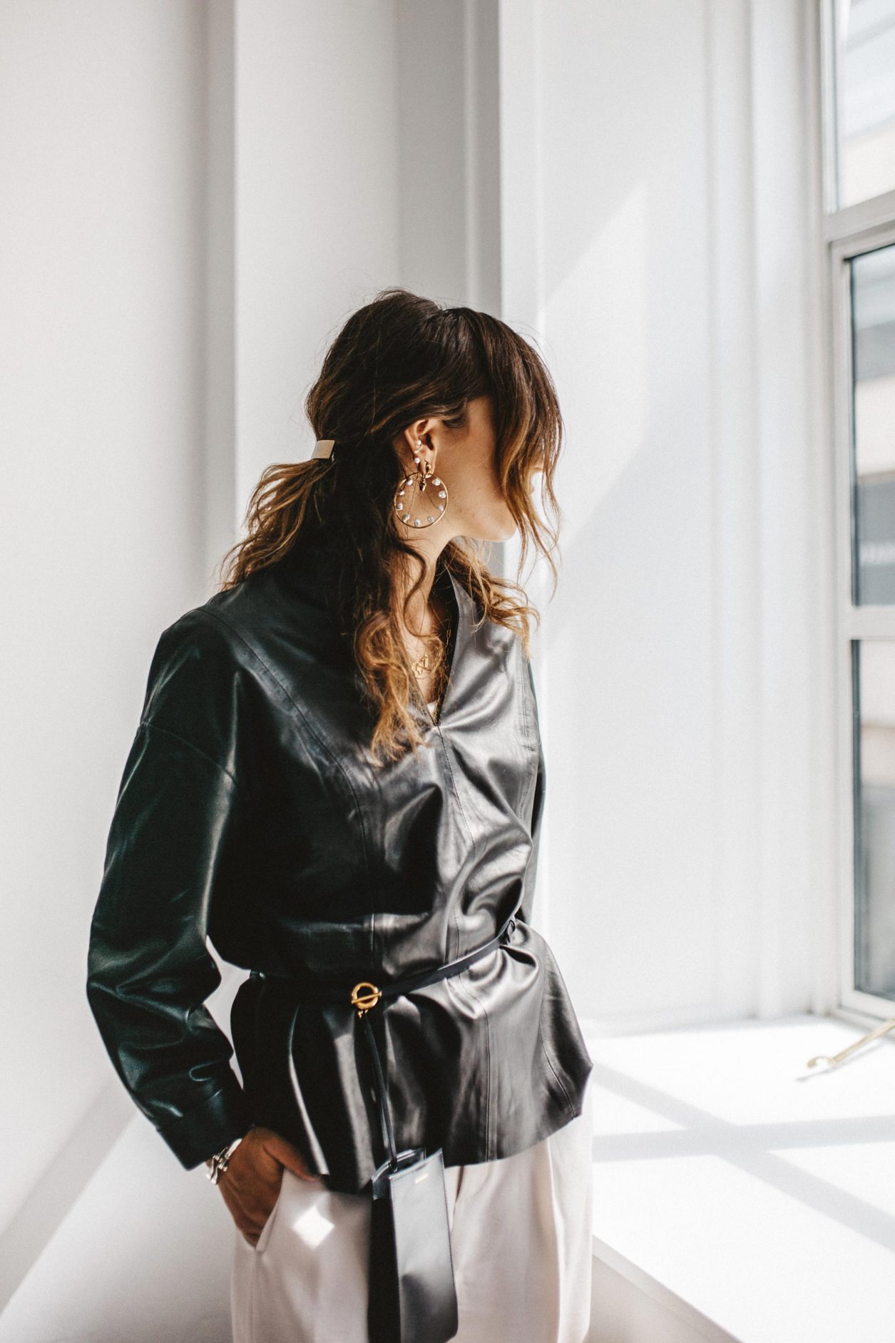 Portrait by Masha Sedgwick at the CPHFW SS20 wearing black leather shirt by Gestuz, Maria Black jewelry (pearl earring and rings), Thomas Sabo necklace, Rolex watch, belt bag by Jil Sander