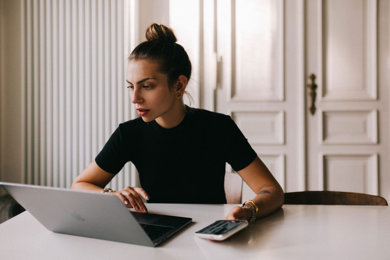 Masha Sedgwick giving financial tipps, business women sitting at the table looking at her laptop