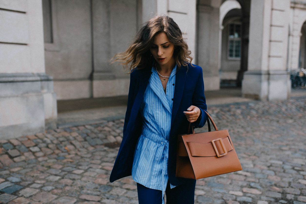 Street style by Masha Sedgwick wearing Lala Berlin at the Copenhagen Fashion Week SS20, blue Lala Berlin suit, brown BOYY bag, stripped blue Lala Berlin asymmetric blouse, Bally loafer