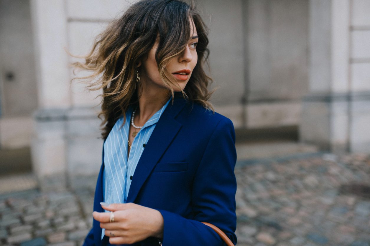 Street style by Masha Sedgwick wearing Lala Berlin at the Copenhagen Fashion Week SS20, blue Lala Berlin suit, brown BOYY bag, stripped blue Lala Berlin asymmetric blouse, Bally loafer