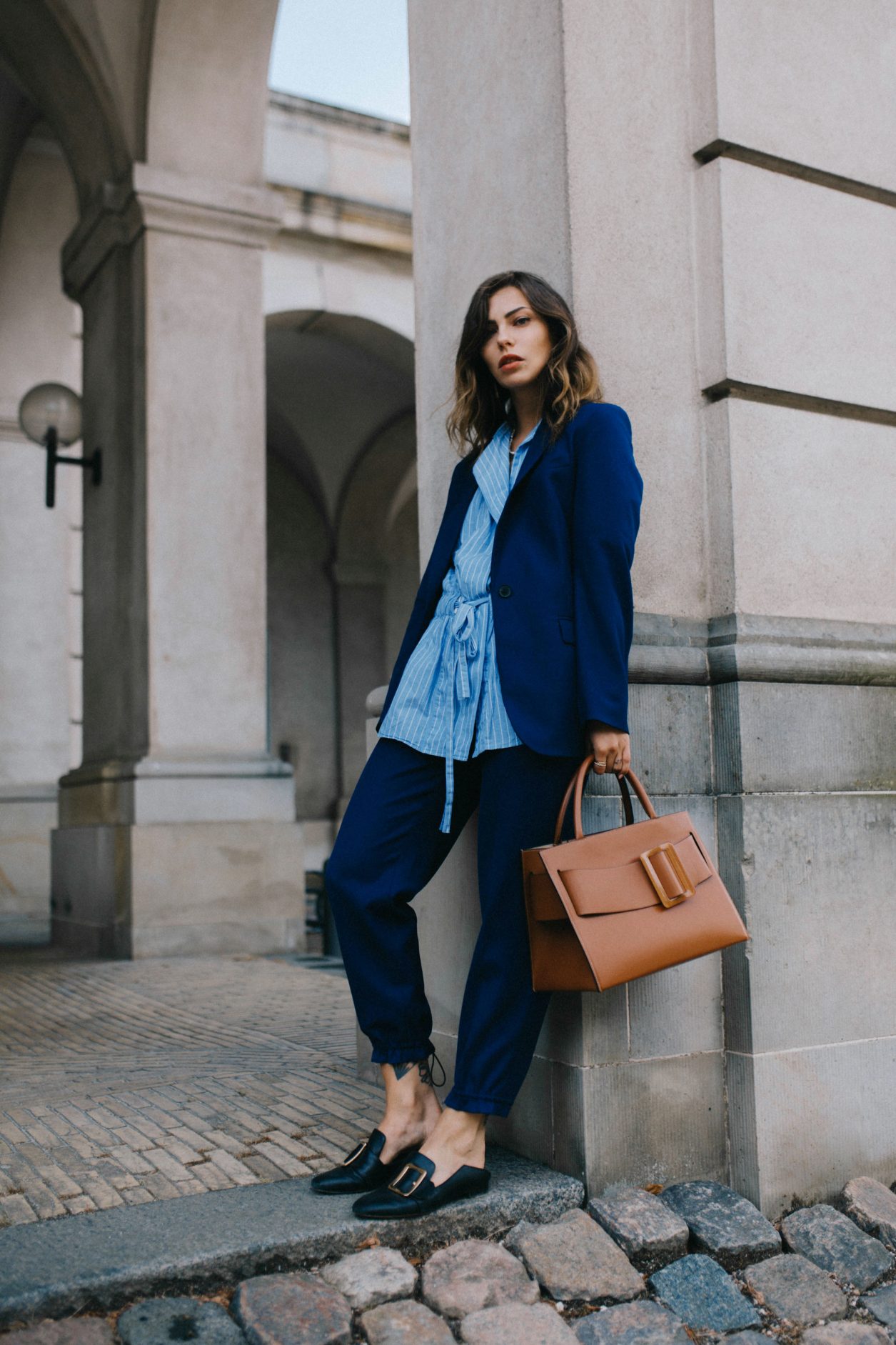 Street style by Masha Sedgwick wearing Lala Berlin at the Copenhagen Fashion Week SS20, blue Lala Berlin suit, brown BOYY bag, stripped blue Lala Berlin asymmetric blouse, Bally loafer