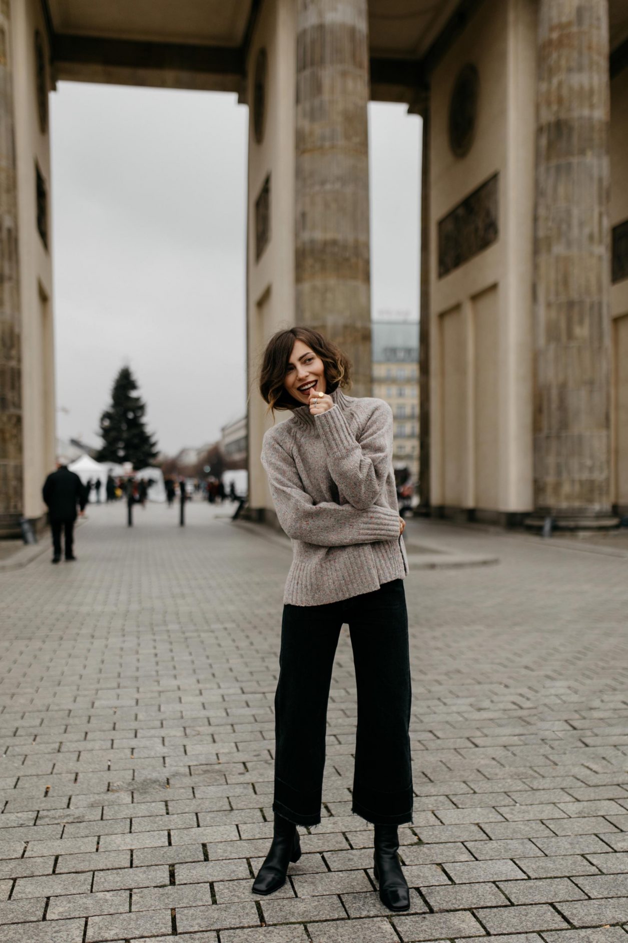 Streetstyle by Masha Sedgwick at the Brandenburger Gate | AW 19 outfit: brown knit Closed, black bootcut jeans Citizens of Humanity , black leather boots Filippa K | Berlin sightseeing photo spot