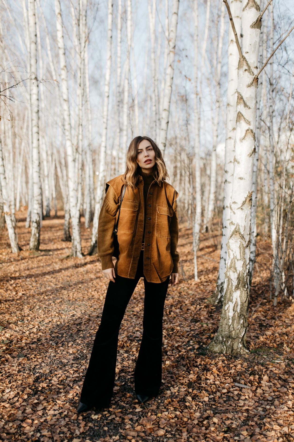 Streetstyle editorial by Masha Sedgwick | Fall winter country style outfit, wearing  tobacco Closed pullover, tobacco cord west by Closed, bootcut jeans by J Brand, brown Escada belt, black black leather cross body bag By Malene Birger | Berlin photo spot: birch park