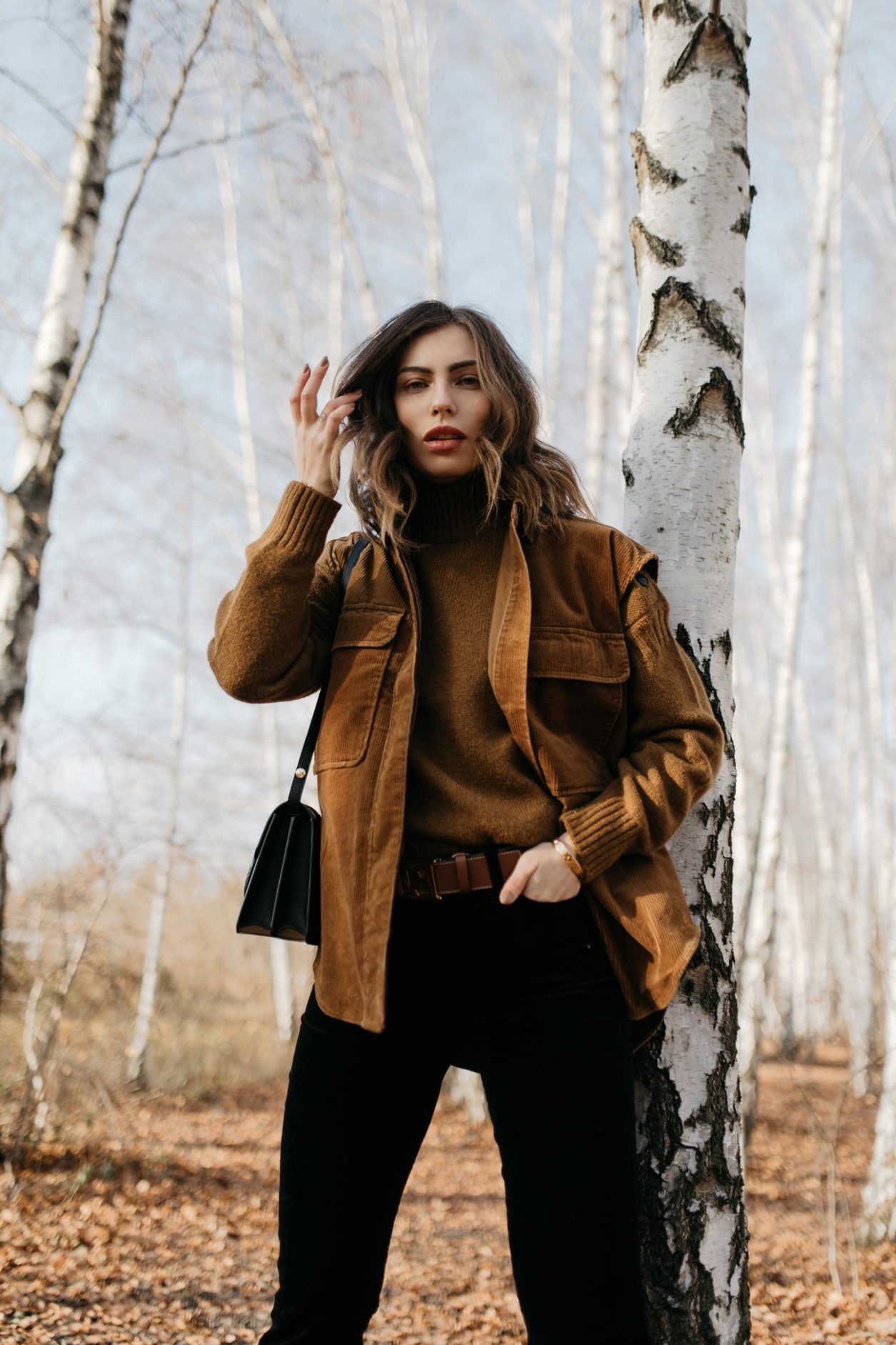 Streetstyle editorial by Masha Sedgwick | Fall winter country style outfit, wearing  tobacco Closed pullover, tobacco cord west by Closed, bootcut jeans by J Brand, brown Escada belt, black black leather cross body bag By Malene Birger | Berlin photo spot: birch park
