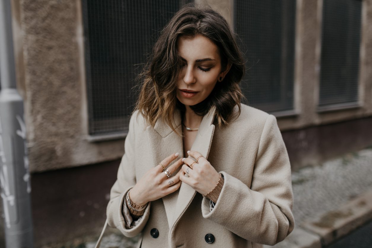 Streetstyle by Masha Sedgwick | Early spring city outfit inspiration, wearing beige classic Closed coat, beige-brown-black Yuzefi shoulder bag, grey Closed jeans, black &other Stories loafer with zipper, grey socks, grey Gestuz blazer, wrapped brown Baum & Pferdgarten shirt | Berlin street style editorial shooting