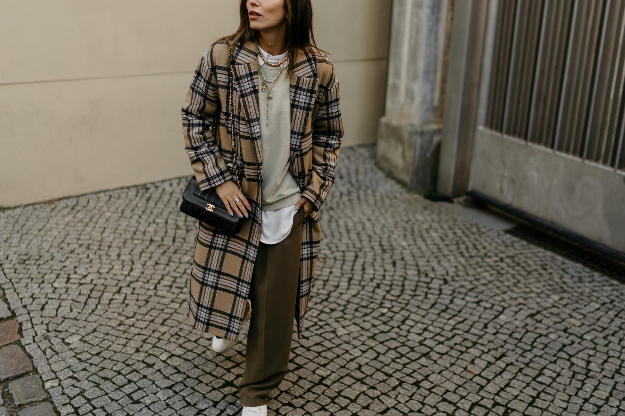 Streetstyle by Masha Sedgwick | Fashion and beauty blogger from Berlin, Germany | Everyday outfit inspiration, feminine casual ootd, cozy spring outfit | Wearing SET fashion beige black checked wool coat, sage green oversized sweatshirt by Topshop, brown wide jogging pants by Topshop, white oversized blouse by SET fashion, white leather Diesel sneaker, black vintage Chanel shoulder bag, golden necklaces