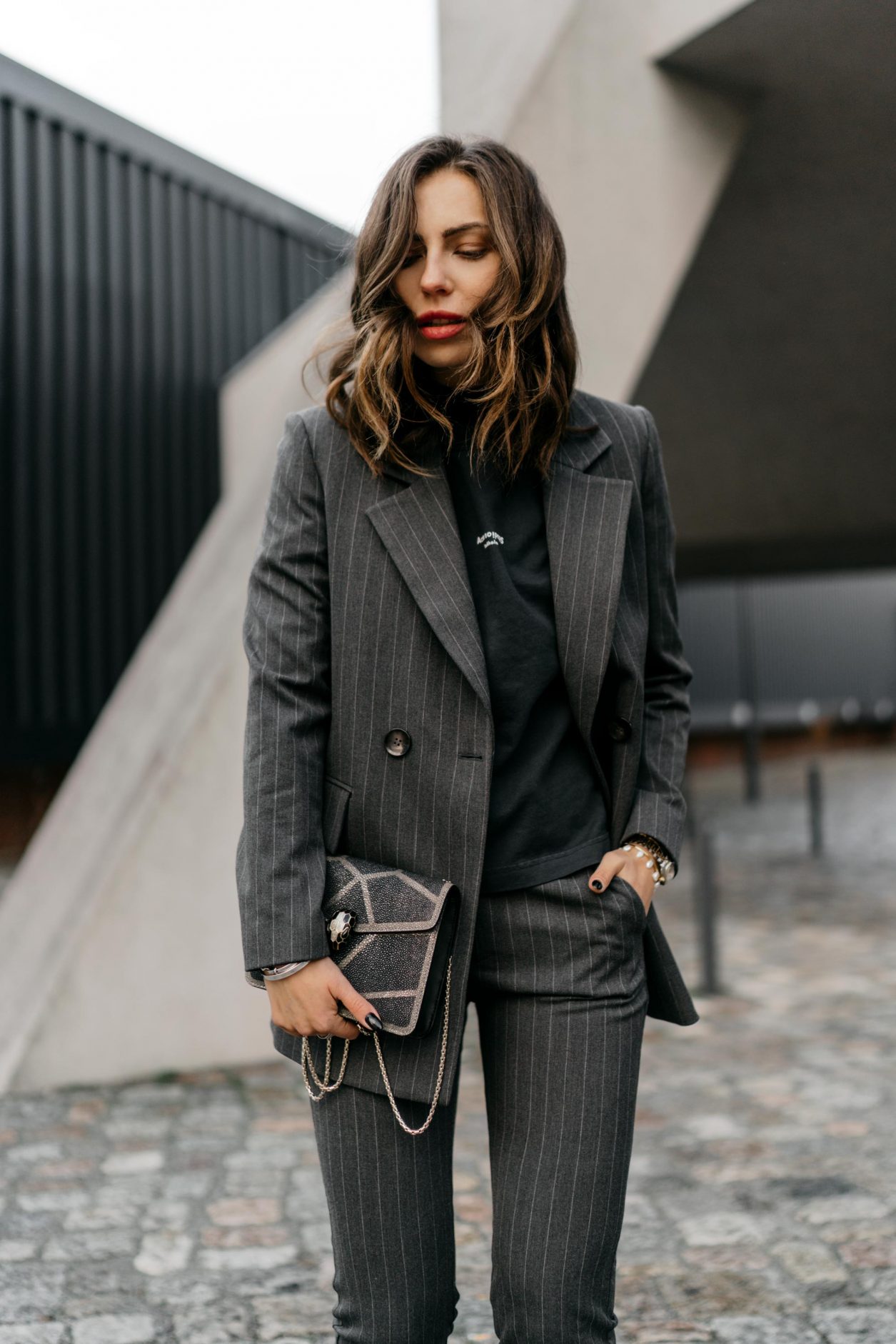 Streetstyle by Masha Sedgwick | Fashion blogger from Berlin | Everyday business outfit ideas, business chic, high end, tomboy style | Wearing grey checked Mango suit, dark grey vintage Celine coat, black leather booties by Flattered, basic logo tee by Acne Studios, glitter mini bag by Bulgari 
