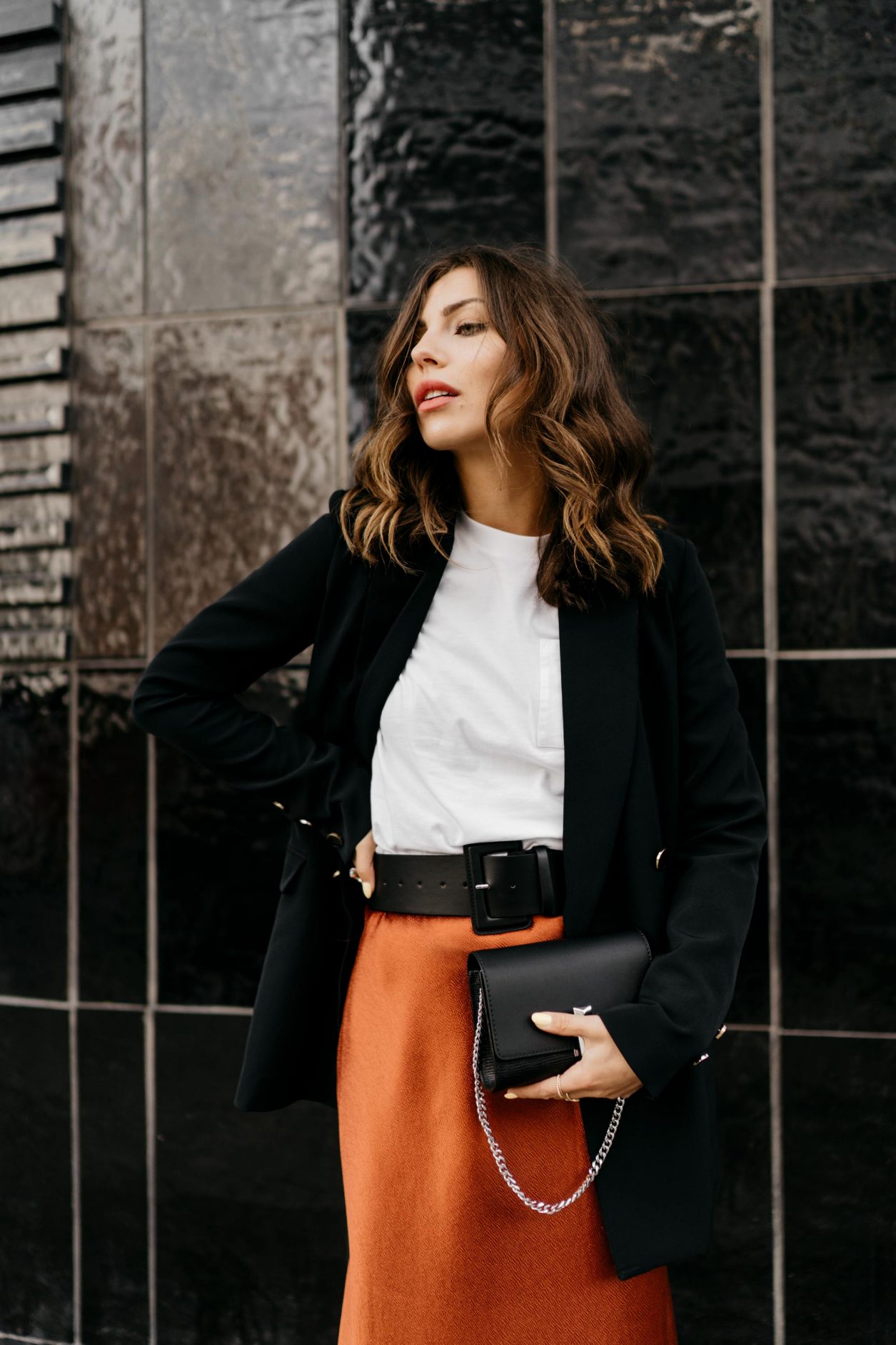 Spring Streetstyle Outfit by Masha Sedgwick | Fashion Blogger from Berlin, Germany | Wearing black Guess blazer, orange red satin Closed midi skirt, black leather belt by Gina Tricot, Calvin Klein Jeans basic white shirt with logo on the pocket, black belt leather BOSS bag, white sneaker by Zign | how to style white sneaker in a business outfit