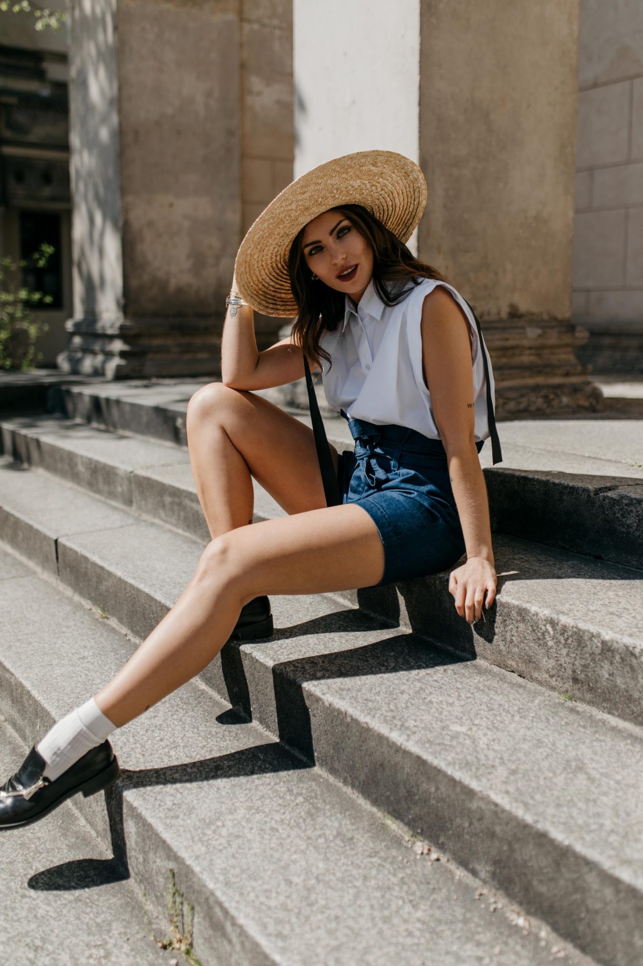 Anzeige | Streetstyle by Masha Sedgwick | Fashion blogger from Berlin, Germany | Spring summer outfit inspiration, minimalistic, english style, effortless cool | Wearing paperbag shorts and sleeveless white blouse by 7 for all mankind, vintage short Burberry coat, straw hat, white socks with black leather loafers