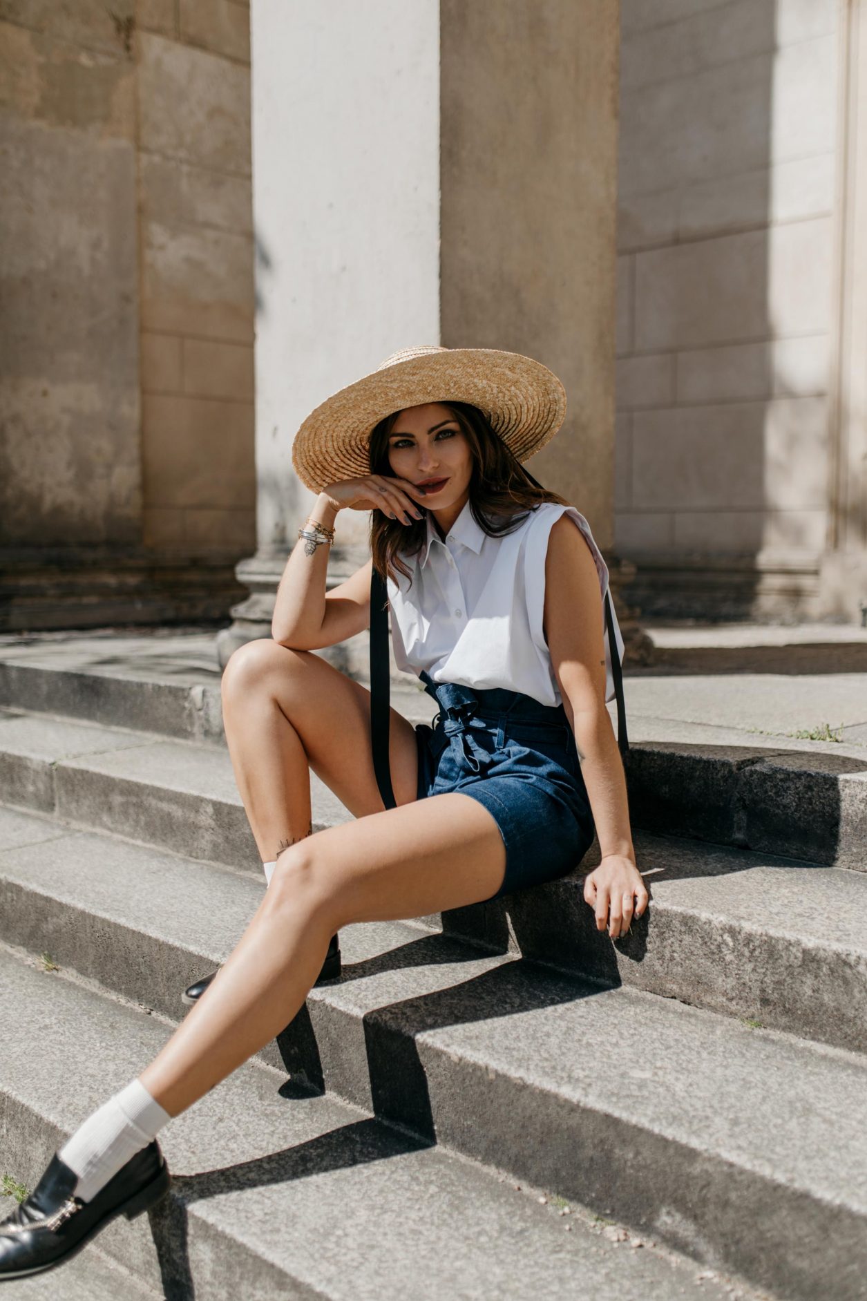Anzeige | Streetstyle by Masha Sedgwick | Fashion blogger from Berlin, Germany | Spring summer outfit inspiration, minimalistic, english style, effortless cool | Wearing paperbag shorts and sleeveless white blouse by 7 for all mankind, vintage short Burberry coat, straw hat, white socks with black leather loafers