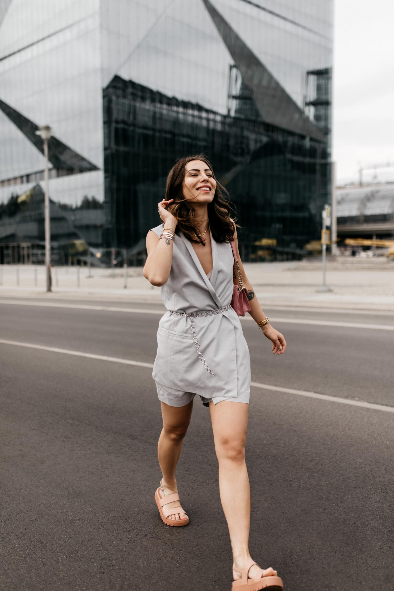Anzeige | Streetstyle by masha Sedgwick | Fashion and beauty blogger from Berlin, Germany | Summer outfit inspiration, two-piece look, effortless cool, summer business outfit with shorts, feminine, chic, high end | Wearing grey COS shorts and top, silver chain belt, pink Miu Miu cross body bag, pink flat Charles & Keith sandals, Shooting spot: Berlin Hauptbahnhof 