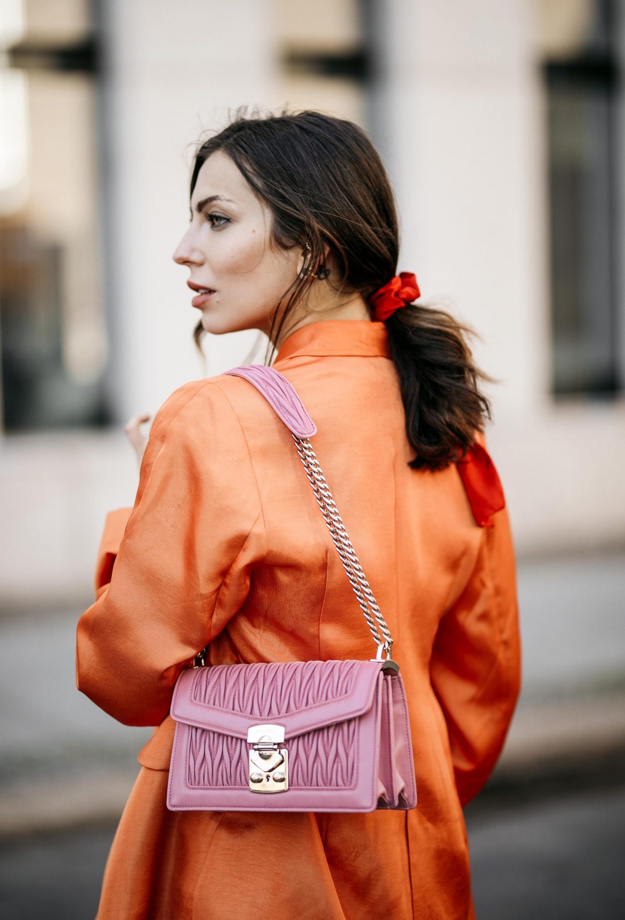 Summer Streetstyle Look by Masha Sedgwick | Photographer: Jeremy Moeller | Summer style trends & outfit inspiration, fashion blogger from Berlin, Germany | Wearing orange Baum Pferdgarten Blazer, graphic grey Acne Studios logo shirt, white leather Copenhagen Muse paperboy shorts, pink Miu Miu shoulder bag, red straps sandals by Charles & Keith | Hair style: messy ponytail
