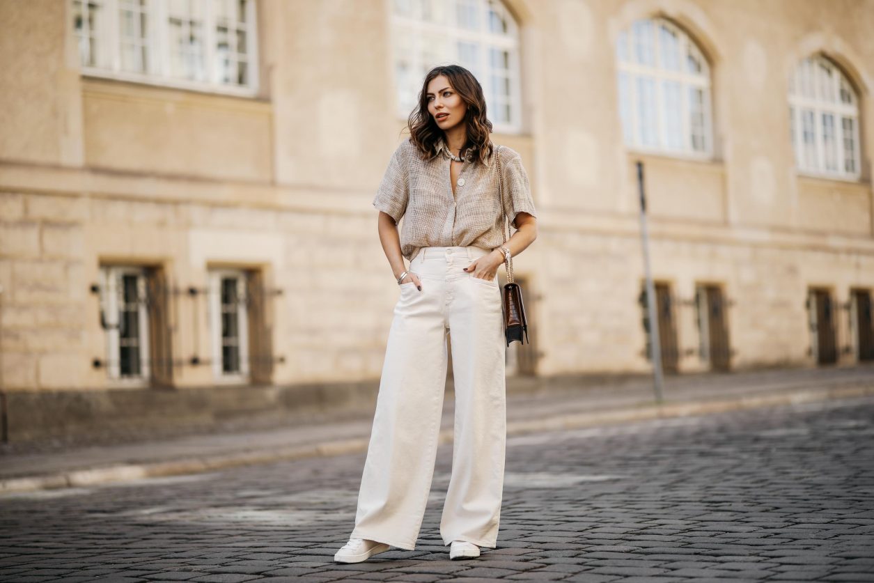 Streetstyle by Masha Sedgwick | Fashion and beauty blogger from Berlin, Germany | Everyday summer outfit inspiration, styling tips white sneakers, casual chic city look, white beige, effortless cool | Wearing wide white jeans, beige linen blouse shirt, cross body brown leather bag, white sneaker | Photographer Jeremy Moeller