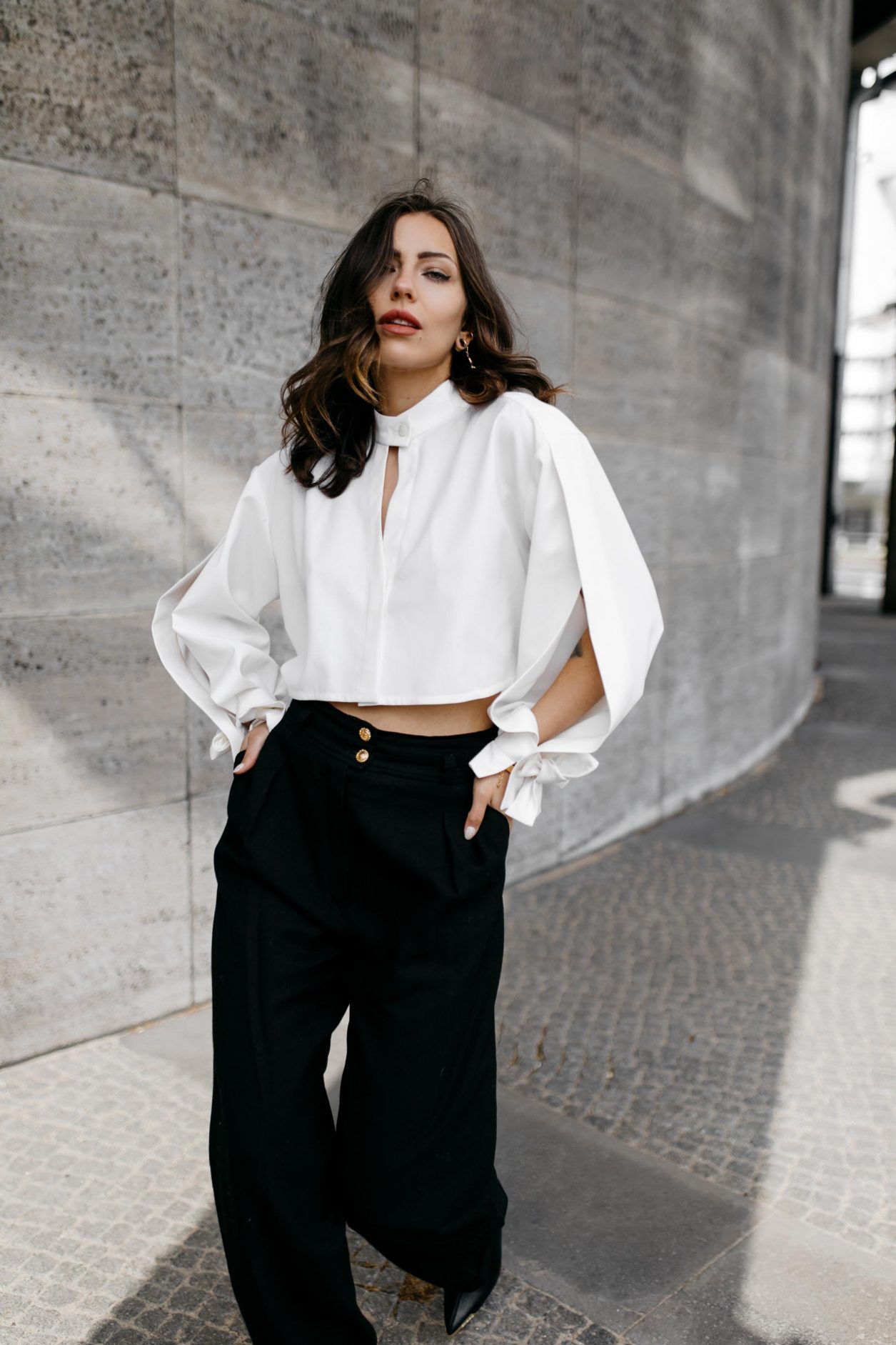 Anzeige | Streetstyle by Masha Sedgwick - fashion and beauty blogger from Berlin, Germany | Photographer Tonya Matyu | Minimalistic black and white outfit, business chic, high end, wearing black vintage Chanel wool pants, white cropped Nobi Talai blouse with puffed arms, dark day make-up, black leather high heels | Photo spot: Berlin Messe ICC 