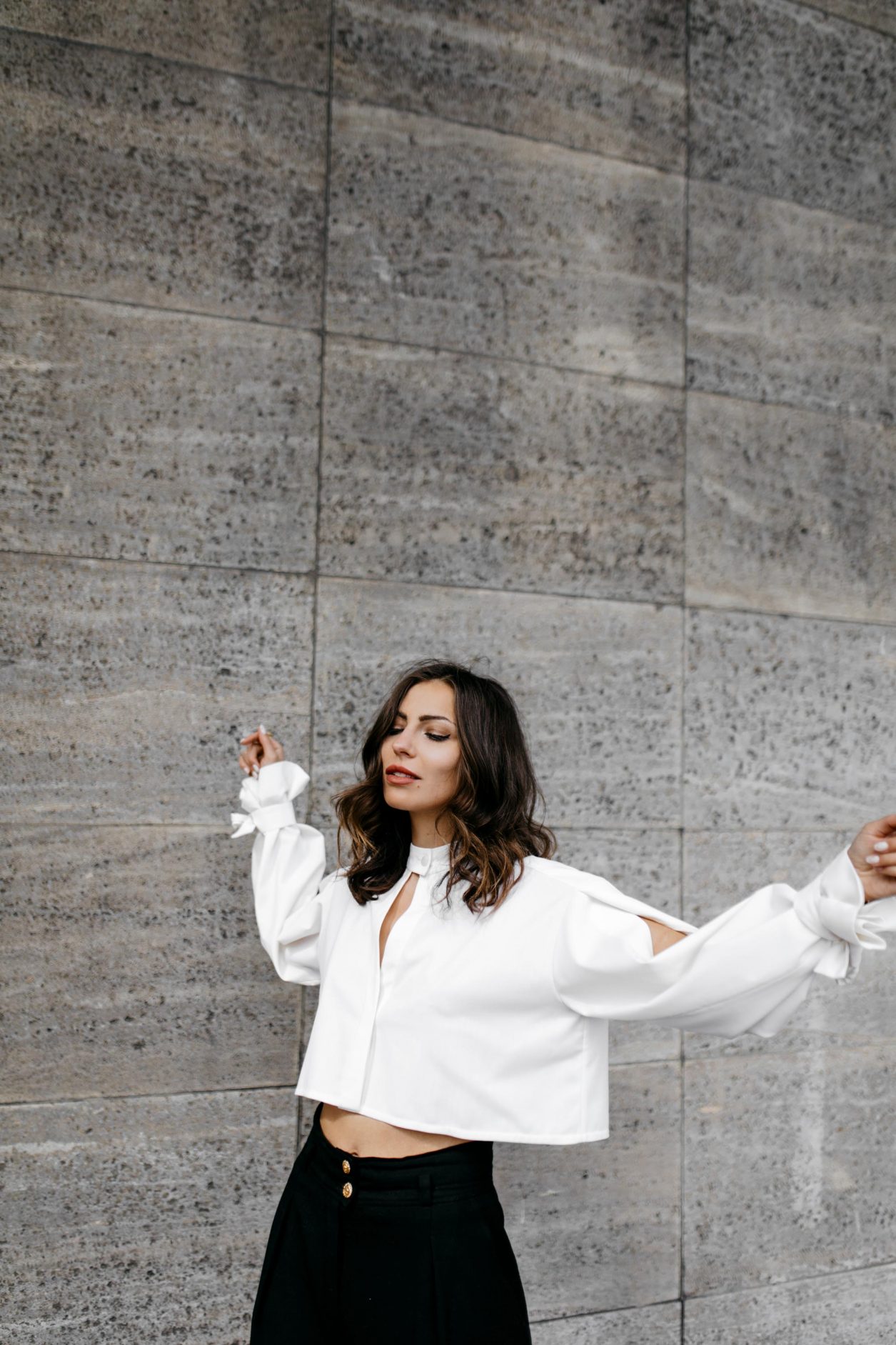 Anzeige | Streetstyle by Masha Sedgwick - fashion and beauty blogger from Berlin, Germany | Photographer Tonya Matyu | Minimalistic black and white outfit, business chic, high end, wearing black vintage Chanel wool pants, white cropped Nobi Talai blouse with puffed arms, dark day make-up, black leather high heels | Photo spot: Berlin Messe ICC 