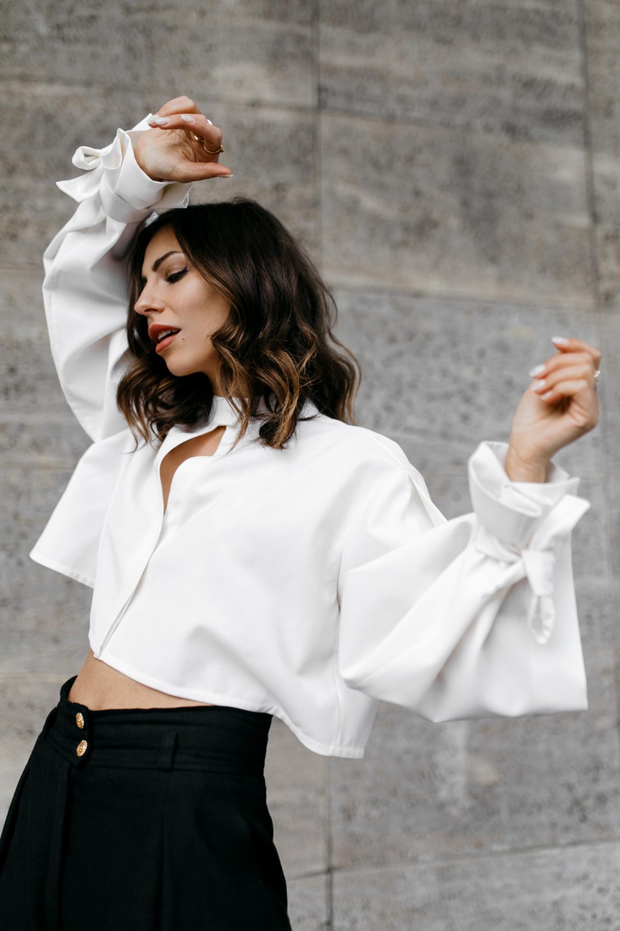 Anzeige | Streetstyle by Masha Sedgwick - fashion and beauty blogger from Berlin, Germany | Photographer Tonya Matyu | Minimalistic black and white outfit, business chic, high end, wearing black vintage Chanel wool pants, white cropped Nobi Talai blouse with puffed arms, dark day make-up, black leather high heels | Photo spot: Berlin Messe ICC 