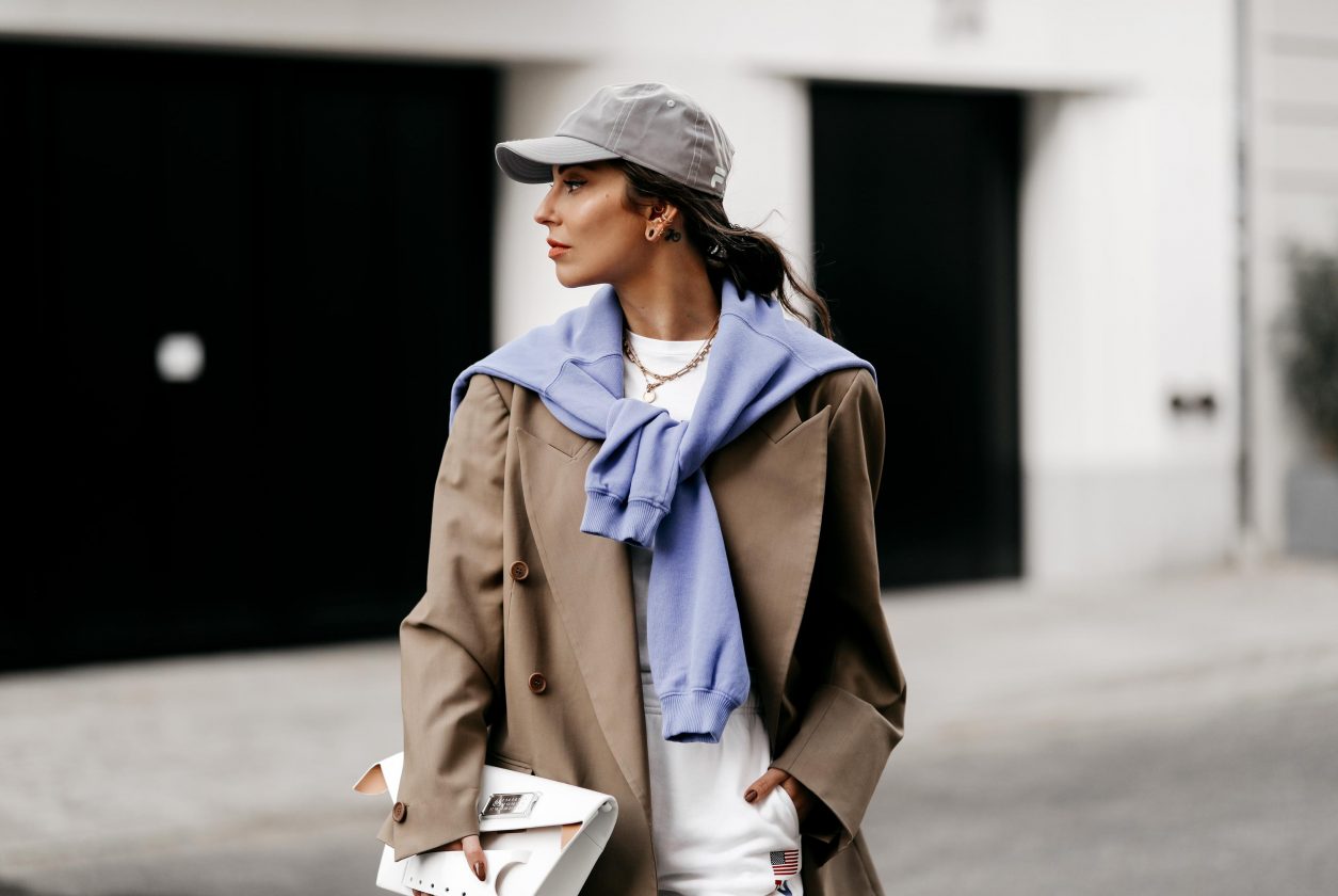 Fashion blogger from Berlin, Germany wearing white jogging Polo Ralph Lauren pants, beige Envelope1976 blazer, lilac sweatshirt, grey Film basecap, white t-shirt, white lack leather Maison Margiela clutch, grey Converse chucks | Spring summer 2021 Streetstyle outfit inspiration, SS fashion trends | photographer Jeremy Moeller