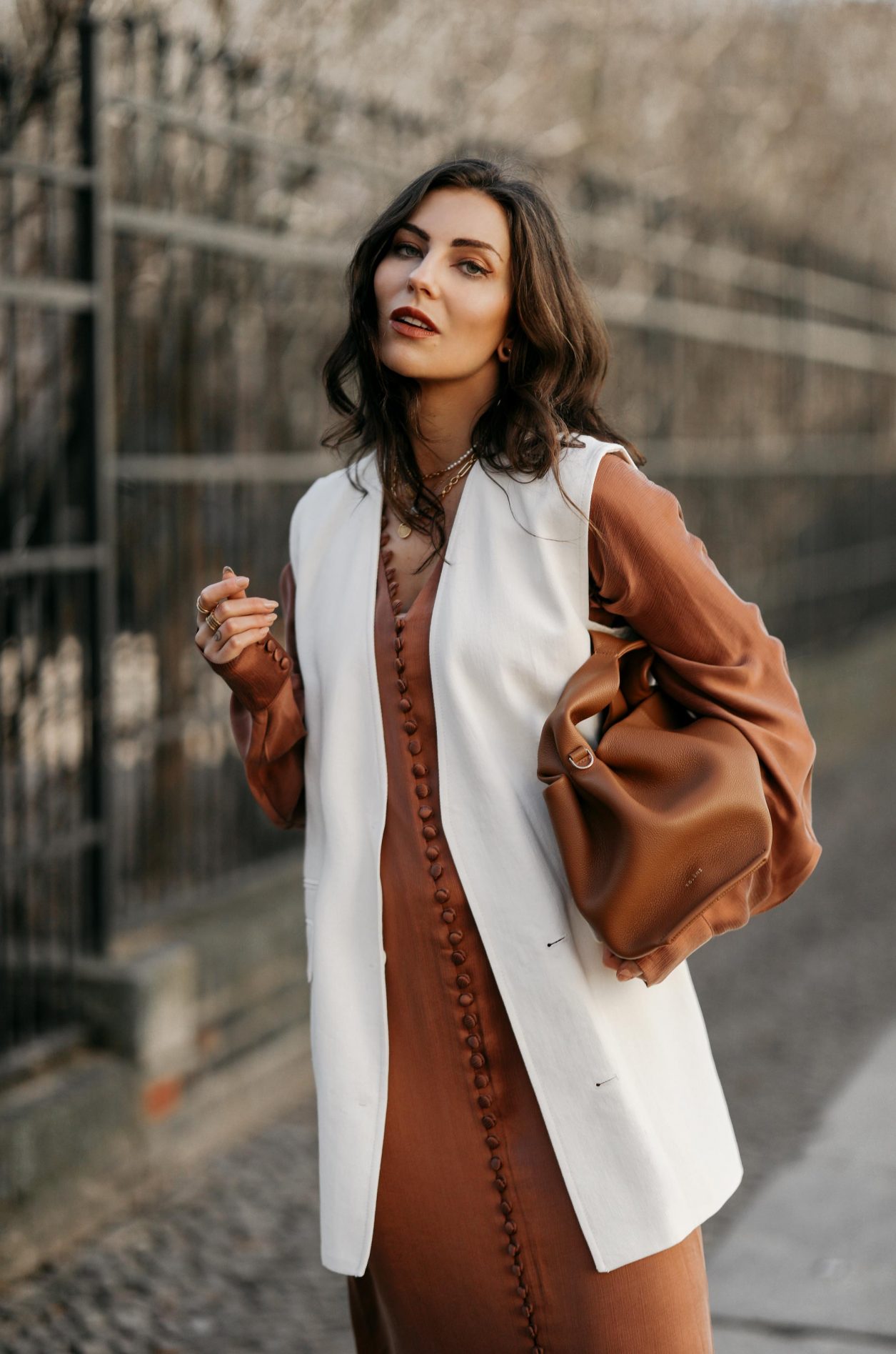 Streetstyle by Masha Sedgwick wearing bronze brown silk buttoned maxi dress by Envelope1976, white Zara blazer west, white slip-on Copenhagen studios sneaker, brown Polene Paris bag | Spring dress styling idea
